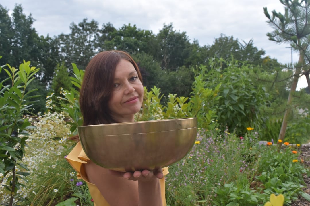 Heilpraktikerin Natalia Altergott mit einer Klangschale in ihrem Garten
